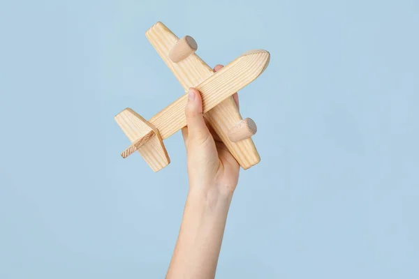 木製の飛行機と女性の手の色の背景 — ストック写真