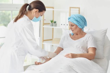 Doktor ve olgun kadın klinikte kimyasal terapi görüyorlar.
