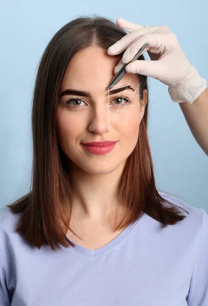 Ung Kvinna Genomgår Ögonbrynskorrigering Förfarande Färg Bakgrund — Stockfoto