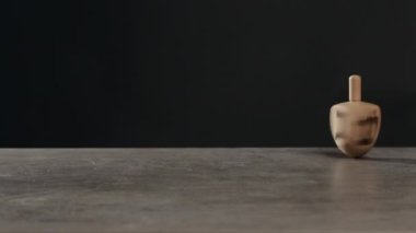 Masada koyu arkaplana karşı dönen dreidel