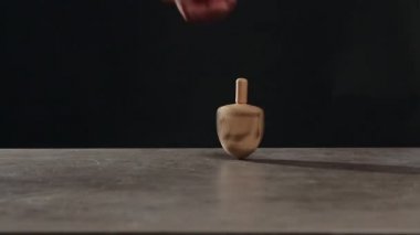 Masanın üzerinde dönen adam koyu arkaplana karşı