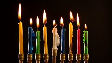 Karanlık arka planda Hanuka için mum yakan Menorah.