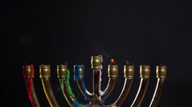 Karanlık arka planda Hanuka için yanmış mumlar olan Menorah.