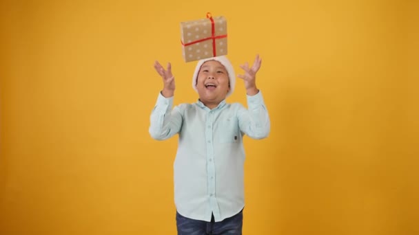 Funny Asian Boy Santa Hat Throwing His Christmas Gift Color — Stock Video