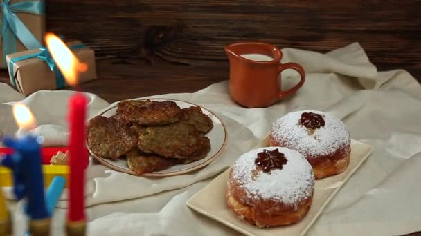 Menorah Med Brinnande Ljus Välsmakande Munkar Potatispannkakor Dreidels Raashaner Och — Stockvideo