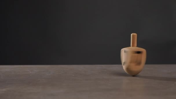 Homem Girando Dreidel Mesa Contra Fundo Escuro — Vídeo de Stock