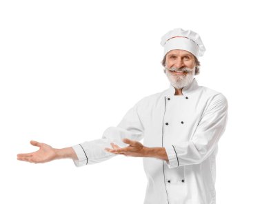 Olgun erkek aşçı beyaz arka planda bir şeyler gösteriyor.