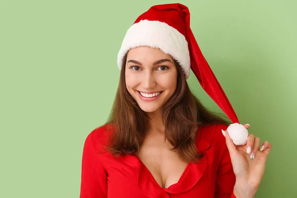 戴着彩色背景圣诞老人帽的年轻漂亮的女人 — 图库照片