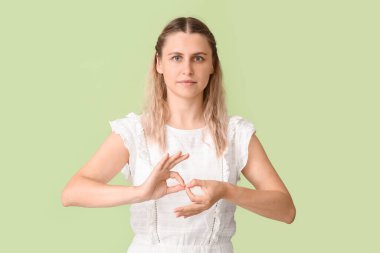 İşaret dilini arka planda kullanan sağır ve dilsiz bir kadın.