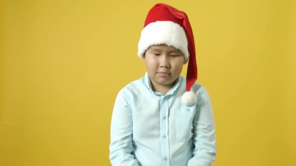 Niedliche Asiatische Junge Mit Weihnachtsmütze Suchen Tasche Mit Weihnachtsgeschenk Auf — Stockvideo