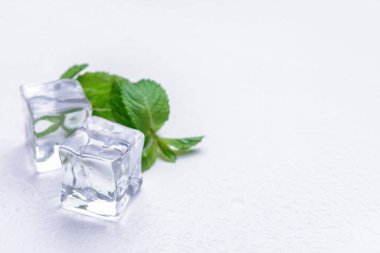 Beyaz arkaplanda buz küpleri ve naneler