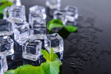 Koyu arkaplanda buz küpleri ve naneler