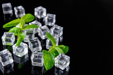 Koyu arkaplanda buz küpleri ve naneler