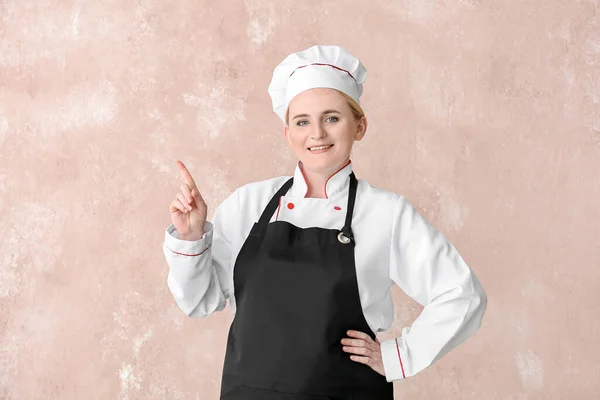 Dojrzałe Kobieta Szef Kuchni Wskazując Coś Tle Koloru — Zdjęcie stockowe