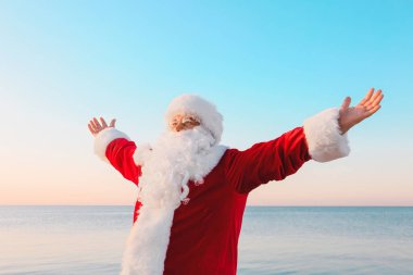 Noel Baba deniz kıyısında dinleniyor. Noel tatili