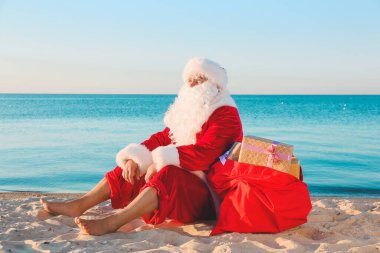 Noel Baba deniz kıyısında dinleniyor. Noel tatili