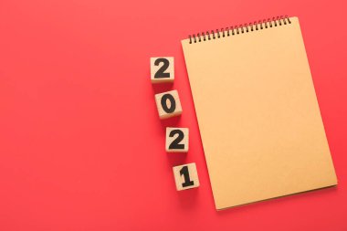 Renk arkaplanı üzerinde şekil 2021 olan defter ve küpler