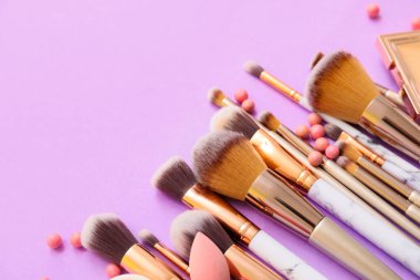 Dekoratif makyaj malzemeleriyle renk arkaplanı üzerine makyaj fırçaları