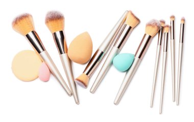 Beyaz arka planda süngerli makyaj fırçaları