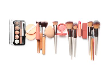 Süslü makyaj fırçaları ve beyaz arka planda süngerler.