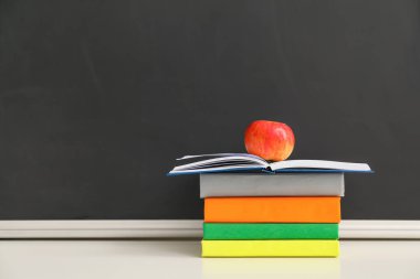 Sınıfta masada elmalı kitaplar.