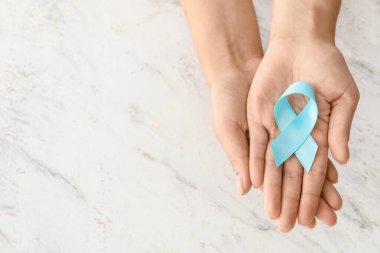Beyaz arka planda farkındalık kurdelesi olan kadın eller. Diyabet kavramı