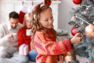 Evde Noel ağacı süsleyen tatlı kız.