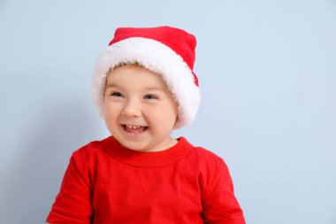 Arka planda Noel Baba şapkalı şirin bir bebek.
