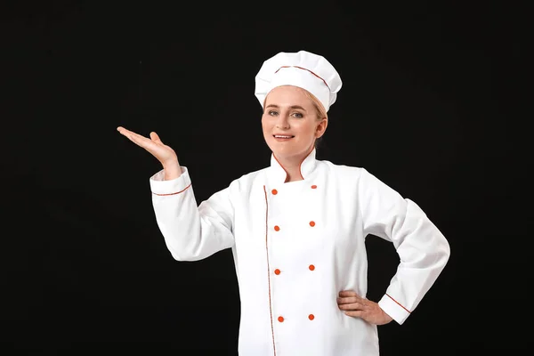 Mature Female Chef Showing Something Dark Background — Stock Photo, Image