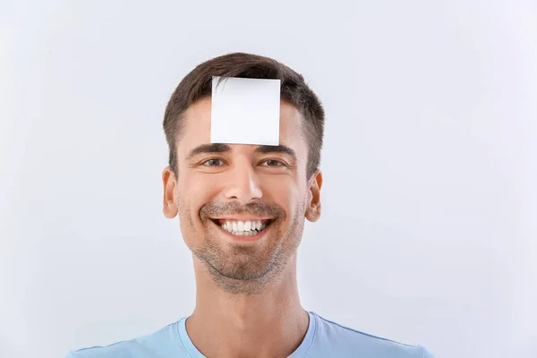 Young Man Small Blank Paper Sheet His Forehead White Background — Stock Photo, Image