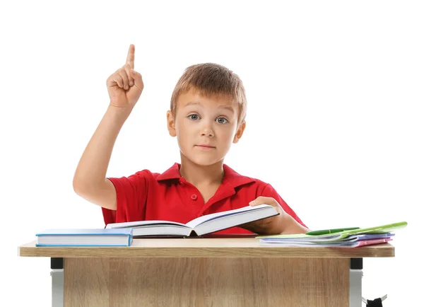 Mały Uczeń Podniesionym Palcem Wskazującym Siedzi Przy Szkolnym Biurku Białym — Zdjęcie stockowe