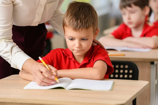 Profesor Ayudando Pequeño Alumno Escribir Durante Lección Aula —  Fotos de Stock