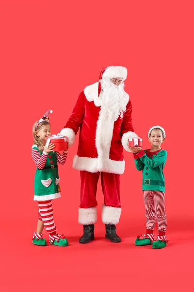 可爱的小精灵 有圣诞老人和彩色背景的圣诞礼物 — 图库照片