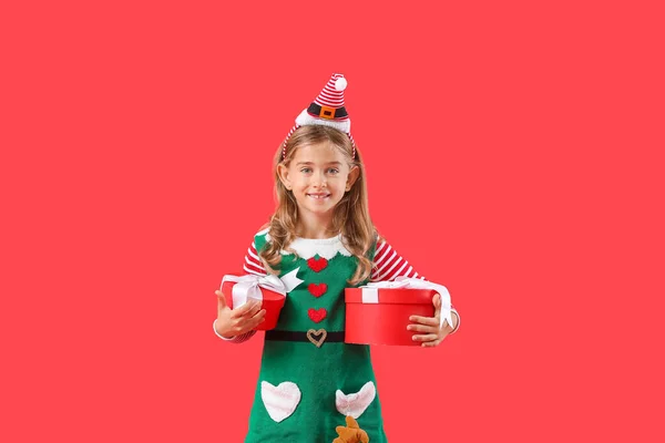 Niedliche Kleine Elfe Mit Weihnachtsgeschenken Auf Farbigem Hintergrund — Stockfoto