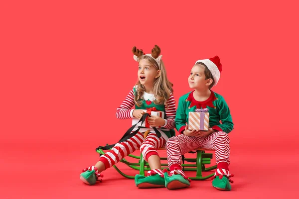 Pequenos Elfos Bonitos Com Presentes Natal Trenó Fundo Cor — Fotografia de Stock