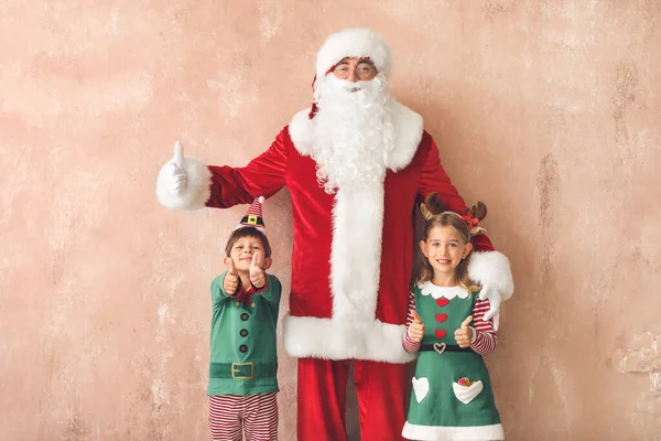 有圣诞老人的可爱的小精灵在彩色背景上表现出大拇指向上的姿态 — 图库照片