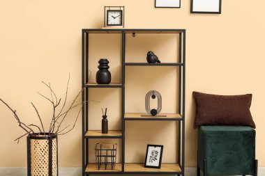 Bej duvarın yanında şık dekorlu siyah raf ünitesi