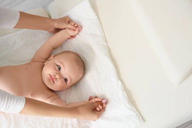 Little baby getting arm massage on couch, top view