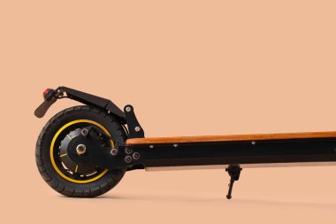 Kahverengi arka planda modern elektrikli scooter, yakın plan.