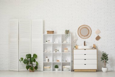 Interior of bathroom with shelf unit, folding screen and sink