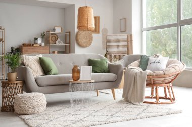 Yumuşak kanepesi, koltuğu, sehpası ve penceresi olan rahat bir oturma odası.