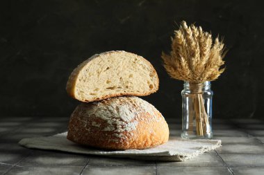 Gri döşeme üzerinde taze ekmek ve buğdayla kesilmiş peçete.