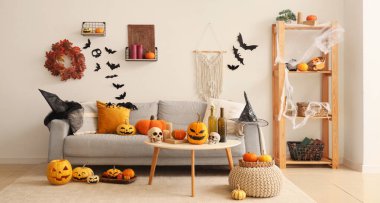 Cadılar Bayramı için dekore edilmiş oturma odasının içi kanepe, masa ve balkabaklarıyla dolu.