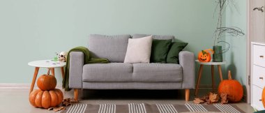 Cadılar Bayramı için dekore edilmiş oturma odasının içi kanepe ve masalarla dolu.