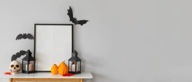 Işık duvarının yanındaki masada Cadılar Bayramı süslemeleri olan boş çerçeve