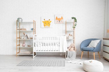 Interior of children's bedroom with crib, shelf units and armchair