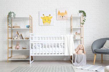 Interior of children's bedroom with crib, shelf units and toys