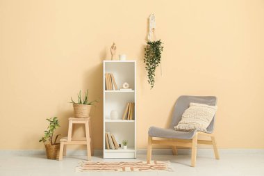 Kitaplığı, sandalyesi ve bitkileri olan bir oda.