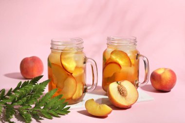 Tepsi ve bir bardak lezzetli şeftali çayı pembe arka planda, yakın plan