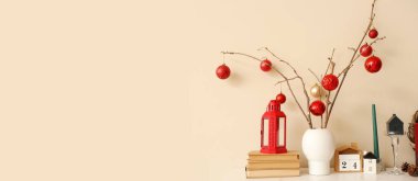 Masasında Noel süsleri, kitaplar ve takvim olan vazo. Tasarım için pankart